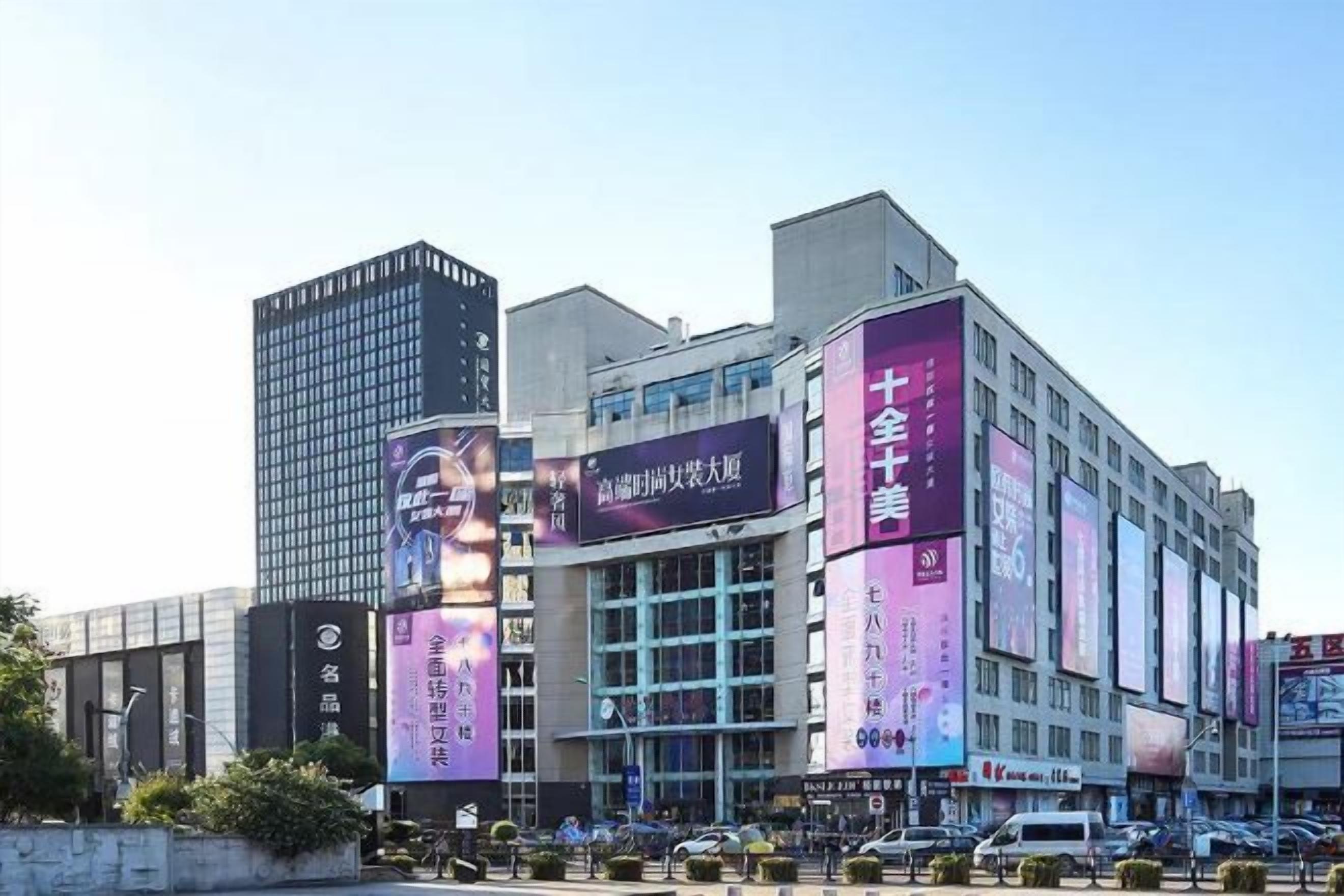 A multi-story building with large digital billboards and a modern architectural design.