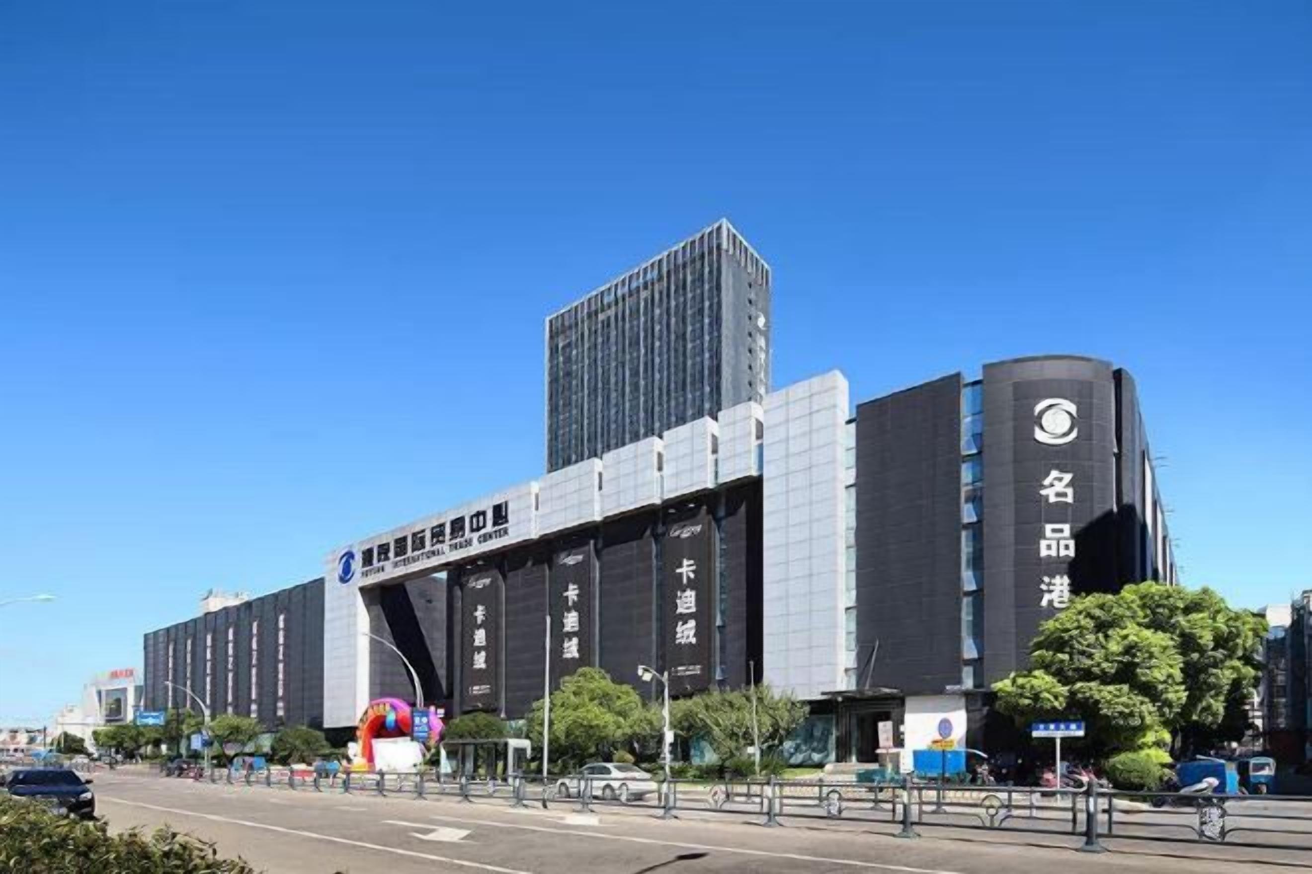 Ein modernes Gebäude mit einem markanten Eingang, großer Beschilderung und blauem Himmel.