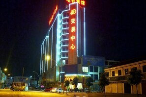 A multi-story hotel with illuminated signage, a prominent entrance, and a street view. - Juntai Maoshan Hotel (Tongxiang)