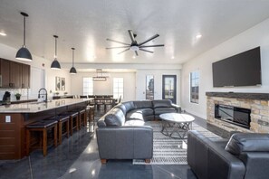 A modern living space with a kitchen, dining area, and seating area. - Impeccable destination for spending quality time with friends & family! (Hurricane)