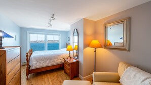 Une chambre à coucher avec un lit, une commode et deux lampes.