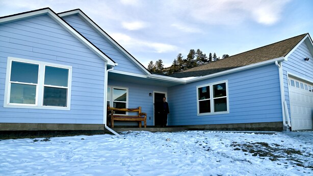 A two-story house with a blue exterior, a front porch with a bench, and a garage. - New Home on 5 acres, Clean, Quiet Comfortable with Private Dog Park (Columbus)