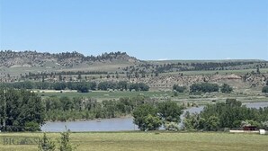A rural landscape with a lake, rolling hills, and scattered trees. - New Home on 5 acres, Clean, Quiet Comfortable with Private Dog Park (Columbus)