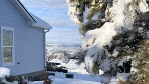A house with snow-covered surroundings, a parked vehicle, and a clear sky. - New Home on 5 acres, Clean, Quiet Comfortable with Private Dog Park (Columbus)