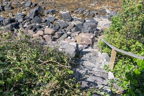 Un terrain rocheux traversé par un sentier en bois.
