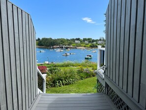Una terraza de madera con vistas a un puerto lleno de barcos.