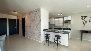 Una cucina moderna con isola centrale, sgabelli da bar e parete decorata.