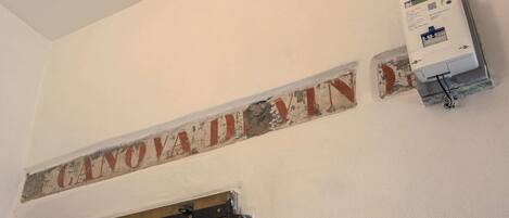 Una pared con un letrero que dice "CANOVA DIVIN" y una caja eléctrica fijada a la pared.