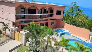 Un edificio de varios pisos con piscina y vista al océano.
