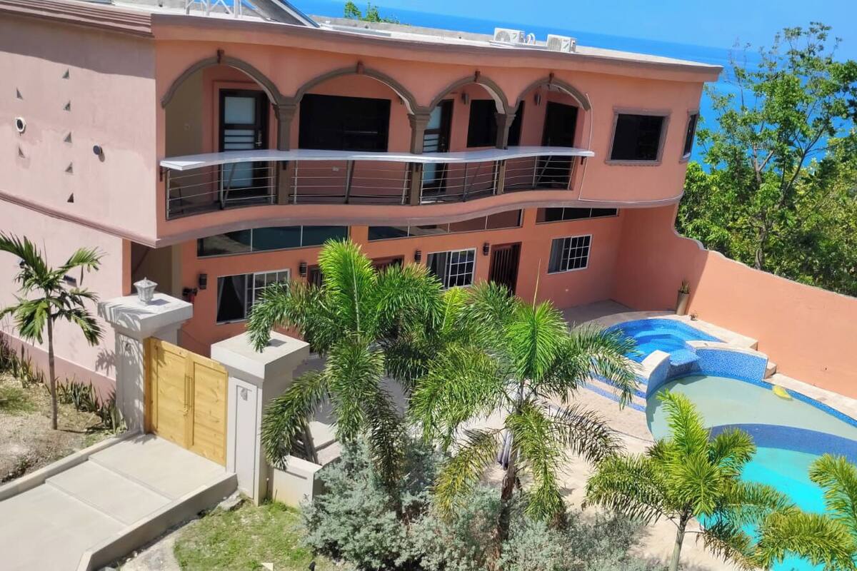 A multi-story building with a pool and a view of the ocean.