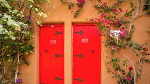 A building with two red doors, each with a small sign above the door. - Dar Tawarta (Dakhla)