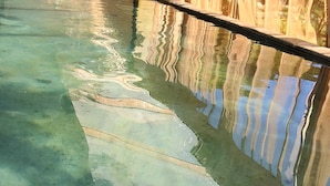 A swimming pool with clear water, wooden beams, and a bamboo fence. - Dar Tawarta (Dakhla)