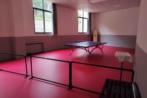 A room with a ping pong table, a small table, and a bench. - Zhao'an Hotel (Zhao'an)