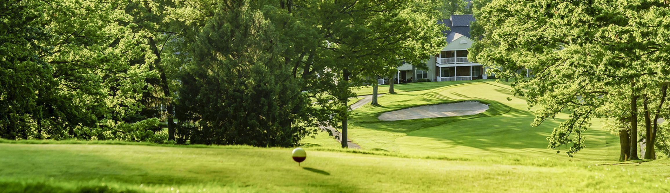 A golf course with a house in the background.