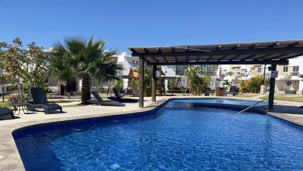A swimming pool with lounge chairs and a pergola. - Casa Almar (Mazatlán)
