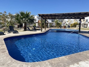 A swimming pool with lounge chairs and a pergola. - Casa Almar (Mazatlán)