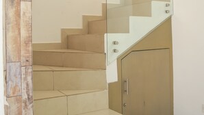 A modern staircase with glass railings and beige steps. - Casa Almar (Mazatlán)