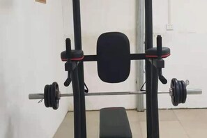 A weightlifting bench with a barbell and weight plates. - Lingyun Zhuangzhi Lingyun International Hotel (Lingyun)