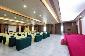 A conference room with rows of chairs, a stage, and a podium. - Lingyun Zhuangzhi Lingyun International Hotel (Lingyun)