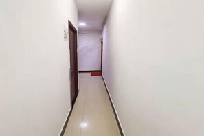 A narrow, well-lit hallway with a door at the end. - Jingpai Hotel (Nanchang)