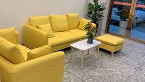 Un conjunto de sofá amarillo con una mesita y una planta en maceta.