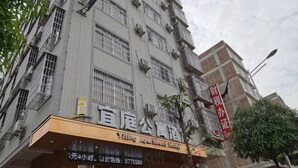 Un edificio con un letrero que dice "Yiting Apartment Hotel" y un letrero rojo que indica "Oficina de Alquiler".