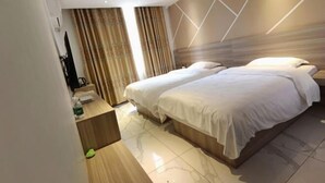 Una habitación de hotel con una cama grande, un escritorio y un televisor.