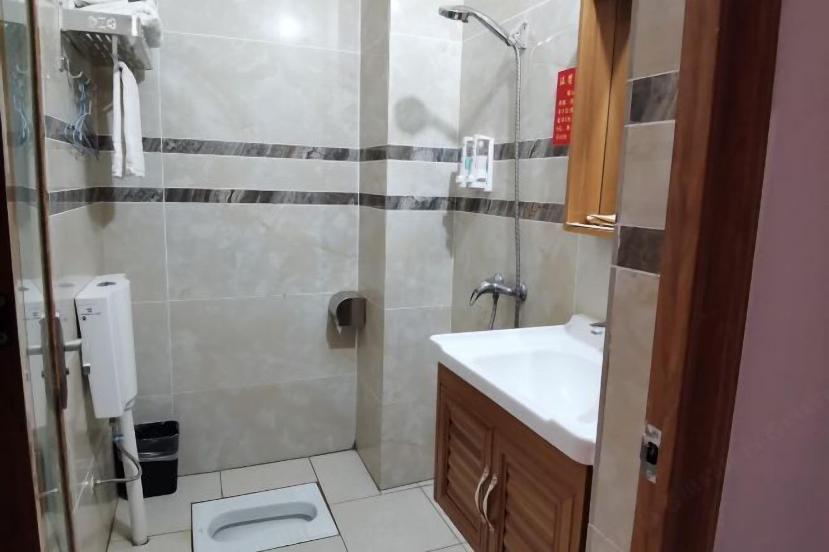 A bathroom with a shower, toilet, and sink.