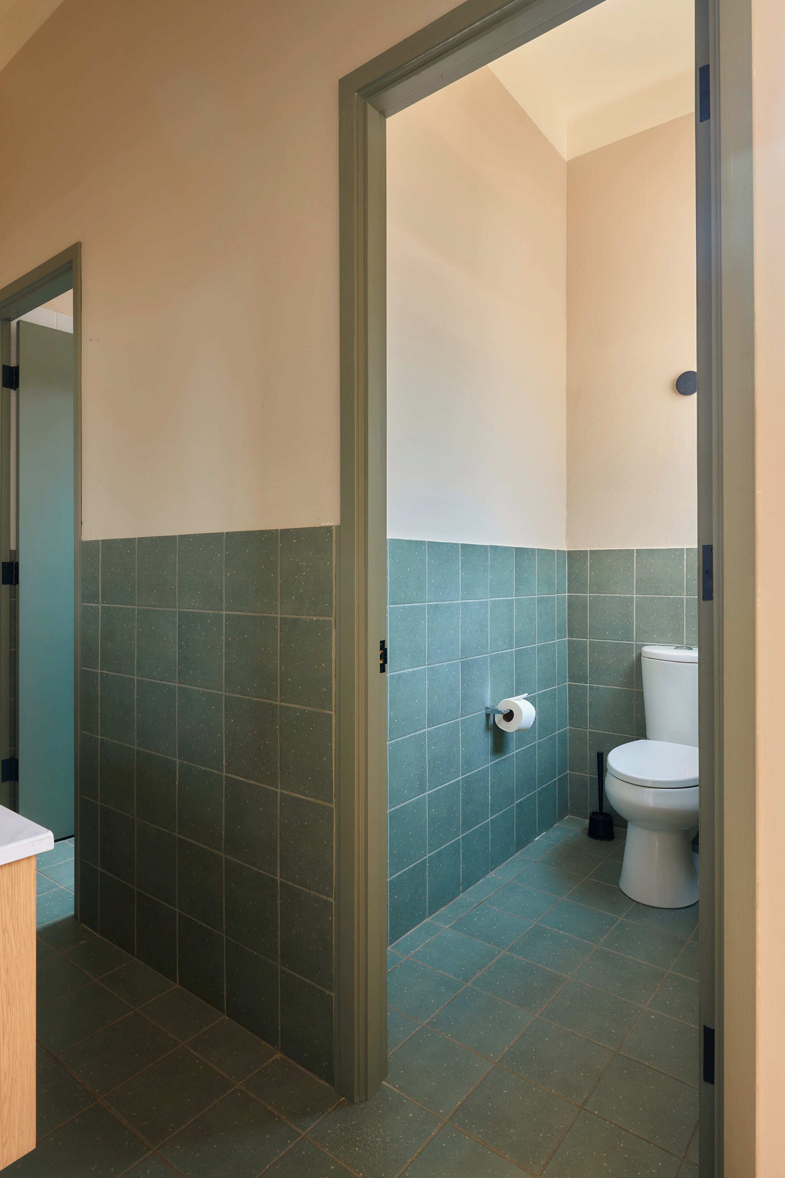 Ein Badezimmer mit Toilette, Toilettenpapier und einer blauen Fliesenwand.