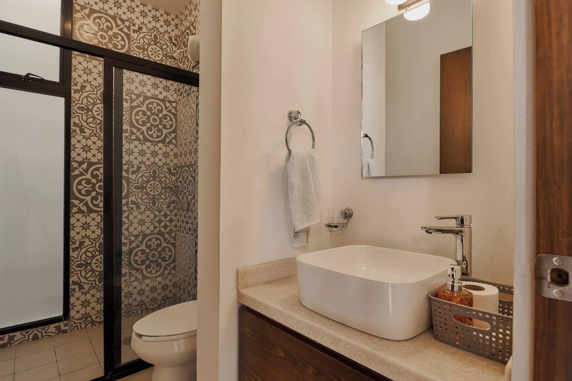 Ein Badezimmer mit einer weißen Badewanne, einer Toilette und einer Wand mit Muster.