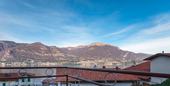 A balcony with a view of a lake and mountains.