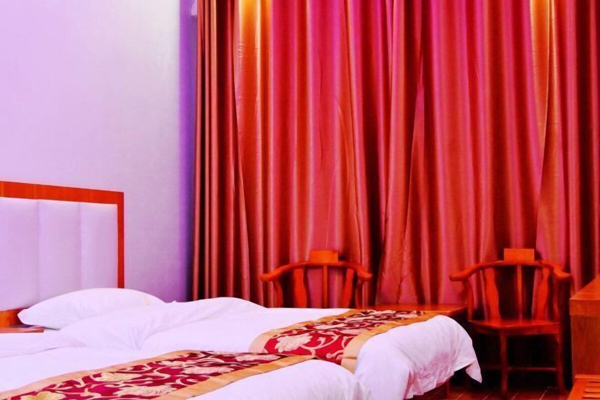 Une chambre d’hôtel avec un lit, deux chaises et un bureau.