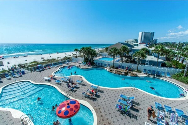 Relax by the pool surrounded by palm trees and beach views, with lounge chairs and umbrellas at your disposal.