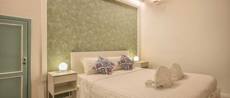 A bedroom with a bed, nightstands, and a door.