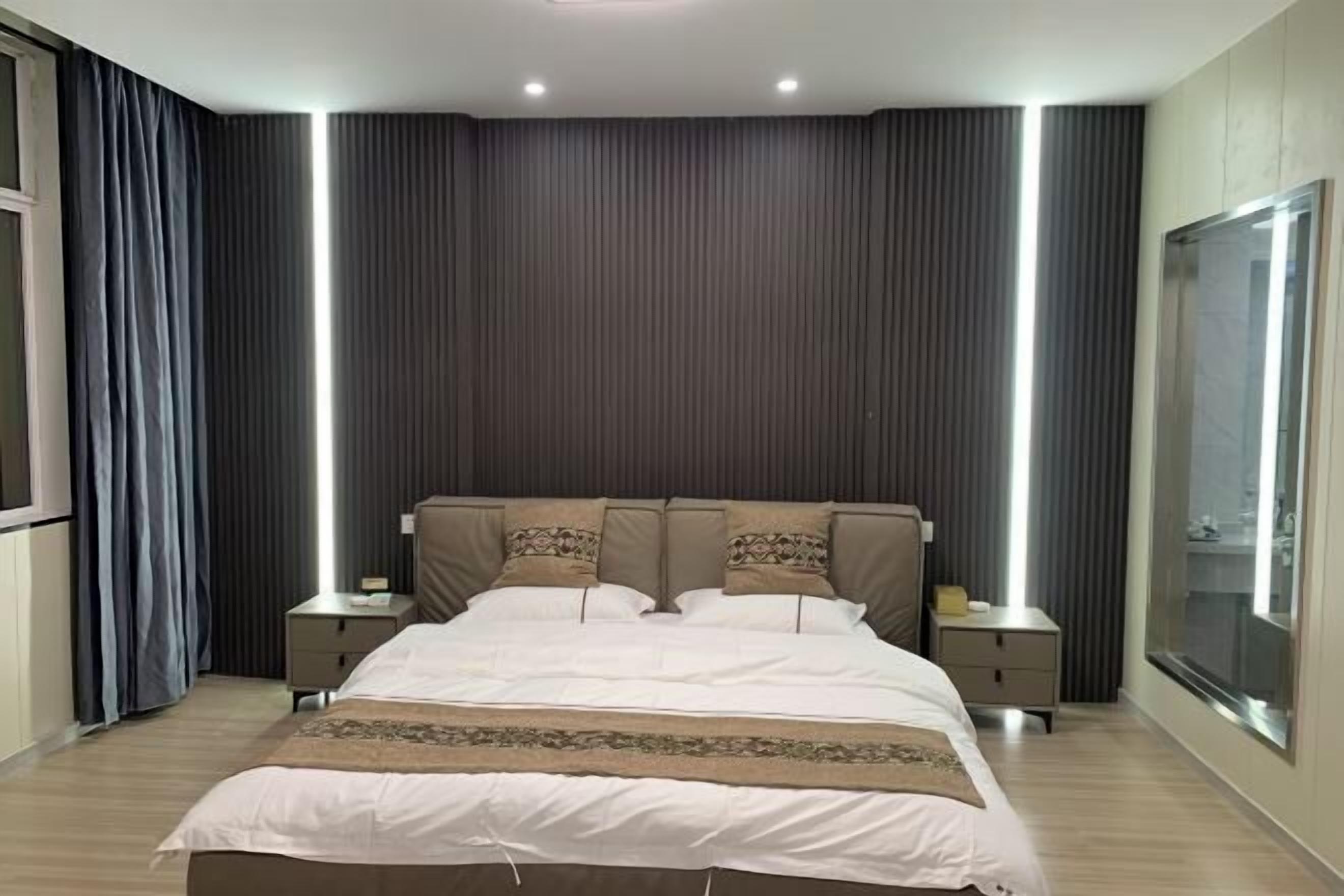 Une chambre d’hôtel moderne avec un grand lit, deux tables de chevet et une grande fenêtre.