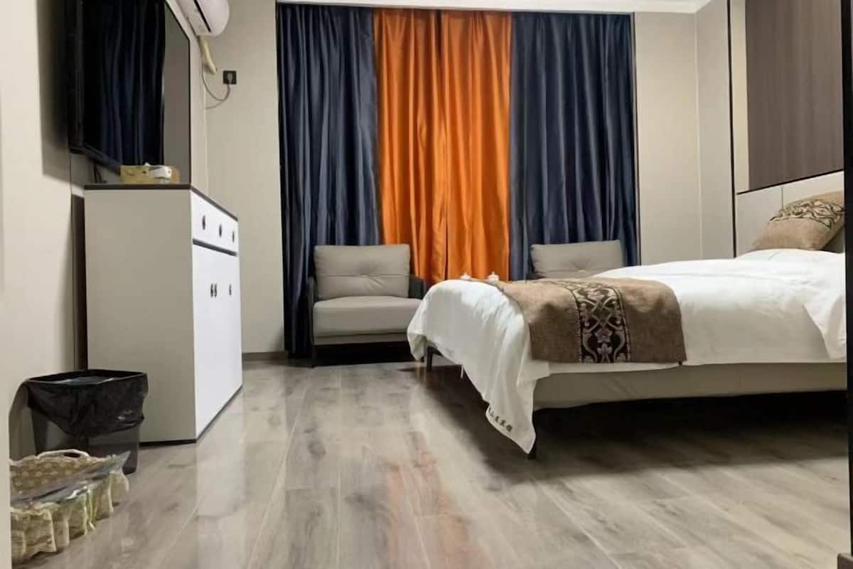 Een slaapkamer met een bed, een bureau en een stoel.