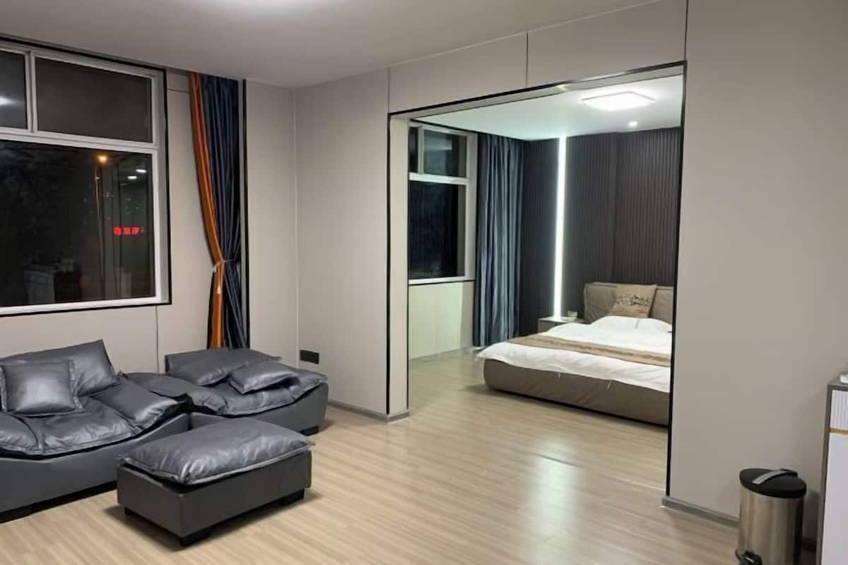 Een moderne slaapkamer met een groot bed, een bank en een kleine tafel.