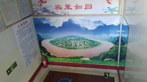 A room with a large mural of a mountainous landscape, a red-framed window, and a fire extinguisher on the floor. - Longcheng Hotel (Shilou)