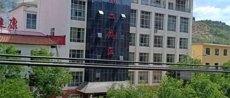 A multi-story building with a prominent sign in red characters.