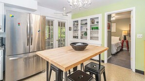A kitchen with a wooden table, stainless steel appliances, and a chandelier. - Lad and Fellow: Downtown Saugatuck Home Near Shops & Restaurants, Pet-Friendly (Saugatuck)