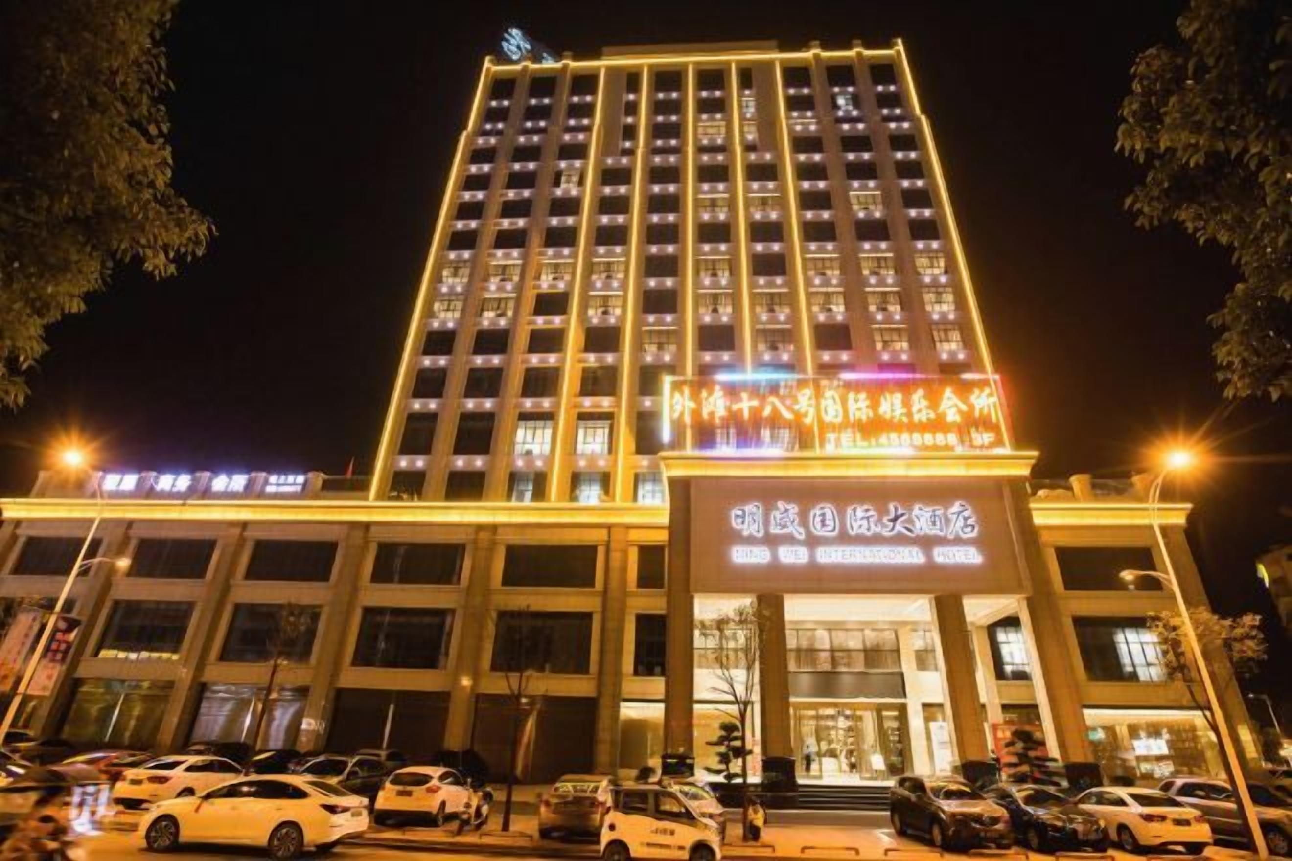 Un hôtel à plusieurs étages, doté d’une enseigne lumineuse et d’un parking situé à l’avant.