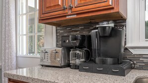 A kitchen with a toaster, a coffee maker, and a blender on the counter.