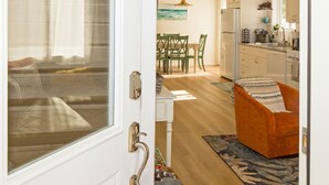 Una cocina moderna con armarios blancos, un refrigerador y un comedor con mesa y sillas.