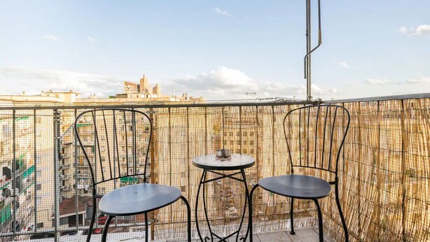 A balcony with two chairs and a small table, overlooking a cityscape with buildings and a clear sky. - FLORENCE HOMEAWAY - COZY APARTMENT NEAR FLORENCE AIRPORT -18 min from City center (Firenze)