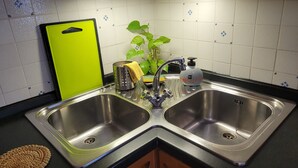 A kitchen with two stainless steel sinks, a yellow cutting board, a green plant, and a soap dispenser. - FLORENCE HOMEAWAY - COZY APARTMENT NEAR FLORENCE AIRPORT -18 min from City center (Firenze)