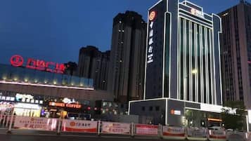 A hotel with a modern facade, a prominent sign, and a well-lit entrance.