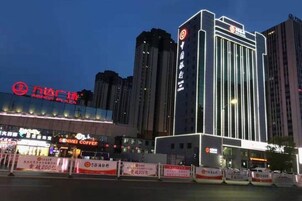 Un hotel con fachada moderna, un letrero llamativo y una entrada bien iluminada.