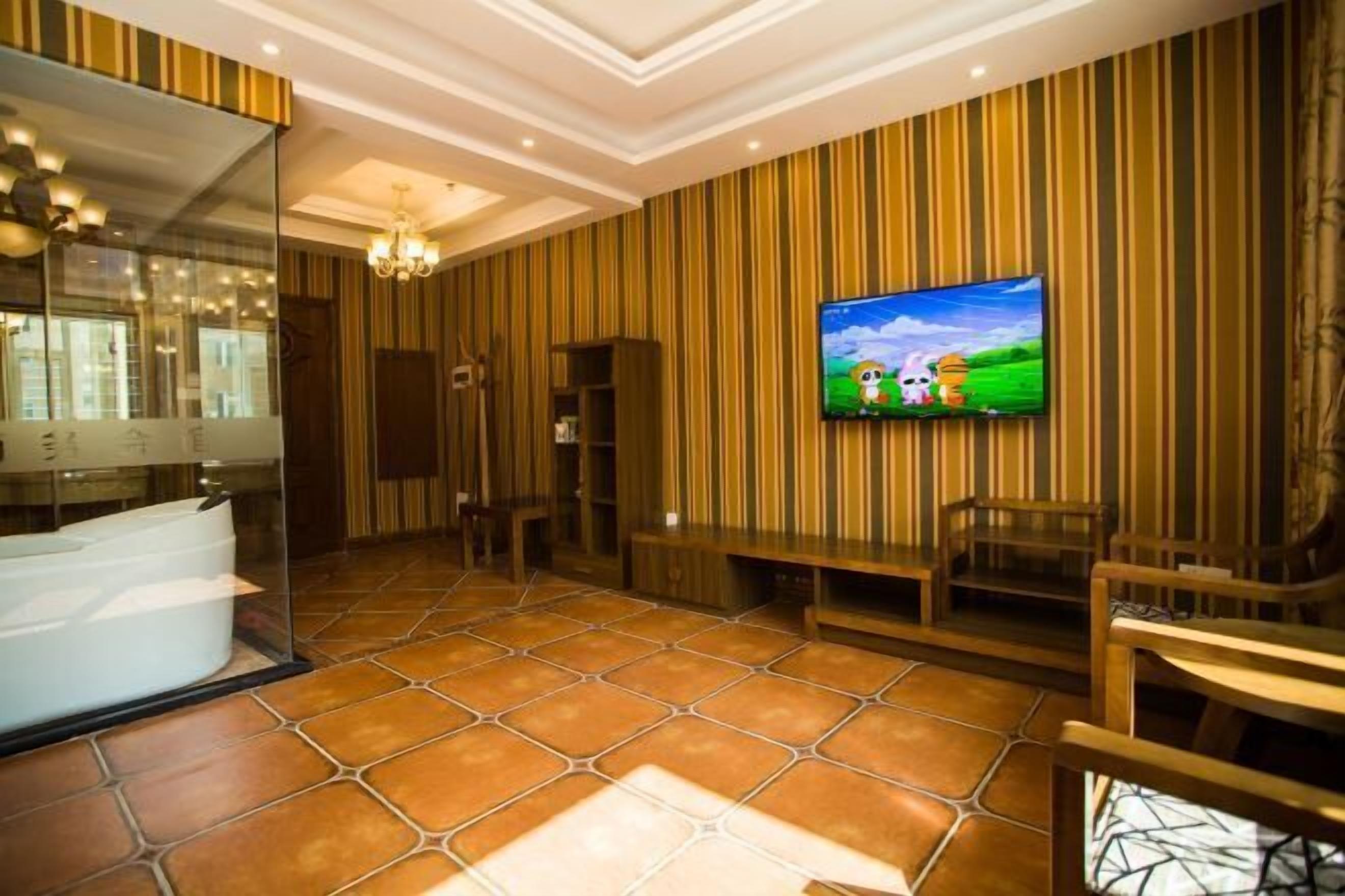Un baño moderno con un espejo grande, una bañera y un televisor montado en la pared.