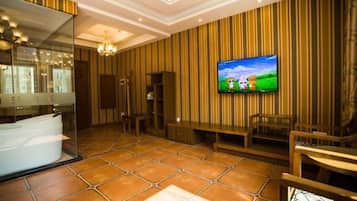 Un baño moderno con un espejo grande, una bañera y un televisor montado en la pared.