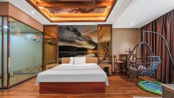 A modern bedroom with a large bed, a hanging chair, and a glass wall.